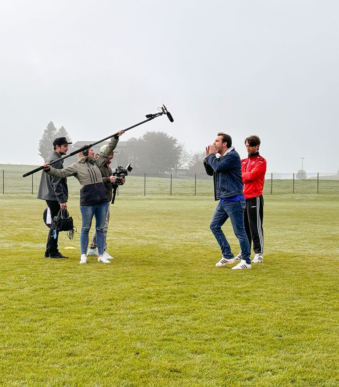 Film-Team & Schauspieler auf einem Fußballfeld